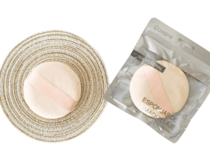 Esponja de maquillaje Coperma de 9 cm con cinta rosa, ideal para aplicar polvos o base con acabado uniforme.