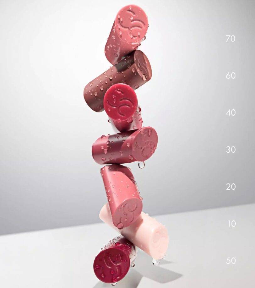 Tapas de los bálsamos Catrice Care In Colours apiladas con gotas de agua