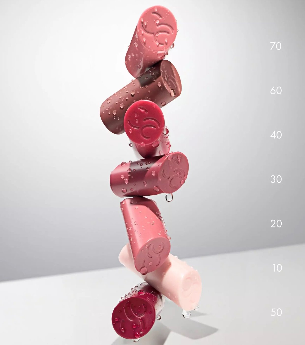 Tapas de los bálsamos Catrice Care In Colours apiladas con gotas de agua