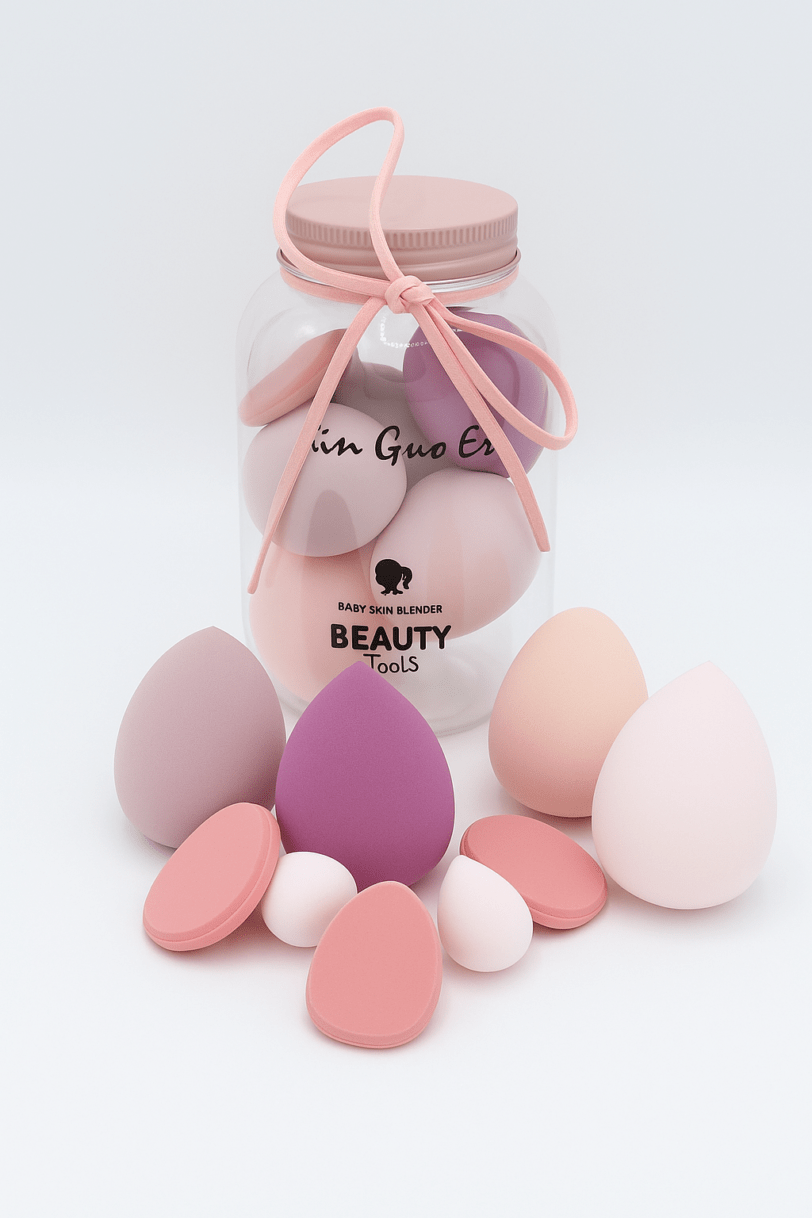 Frasco transparente con esponjas de maquillaje Coperma en tonos pastel y lazo rosa decorativo.