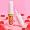 Aceite labial Essence Juicy Bomb Party Watermelon Wonders sobre fondo rosa