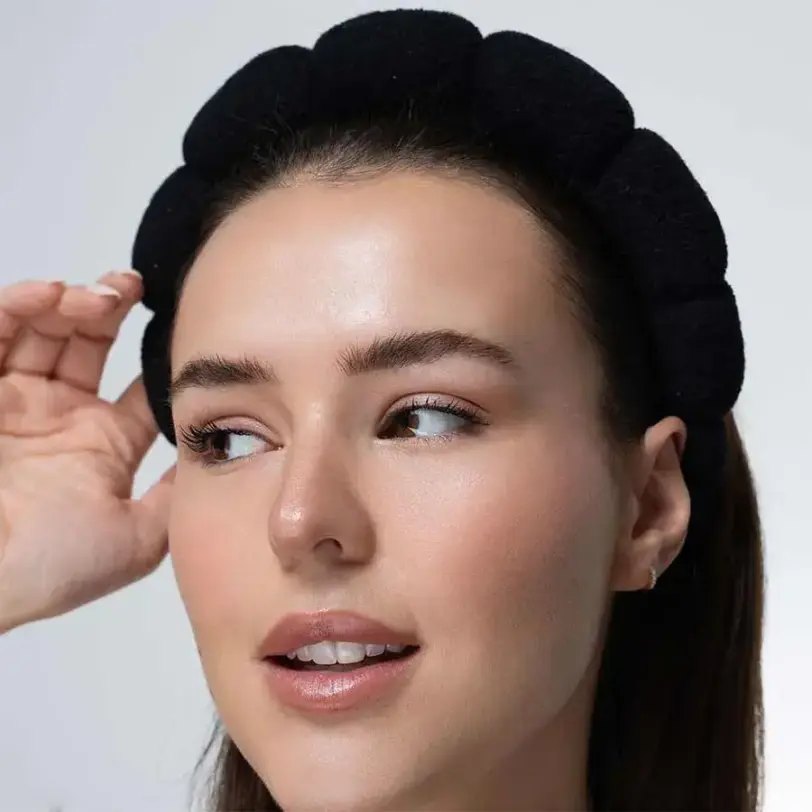 Mujer usando diadema nube Brushworks durante maquillaje