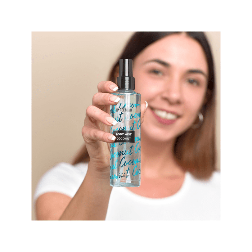 Mujer aplicando body mist de coco Flor de Mayo con fragancia dulce y ligera