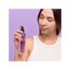Mujer aplicando body mist de frutos rojos Flor de Mayo con fragancia fresca y dulce