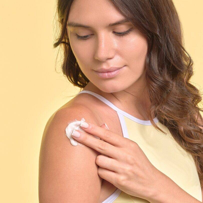 Loción corporal hidratante Flor de Mayo creamy aplicada en hombro con textura suave