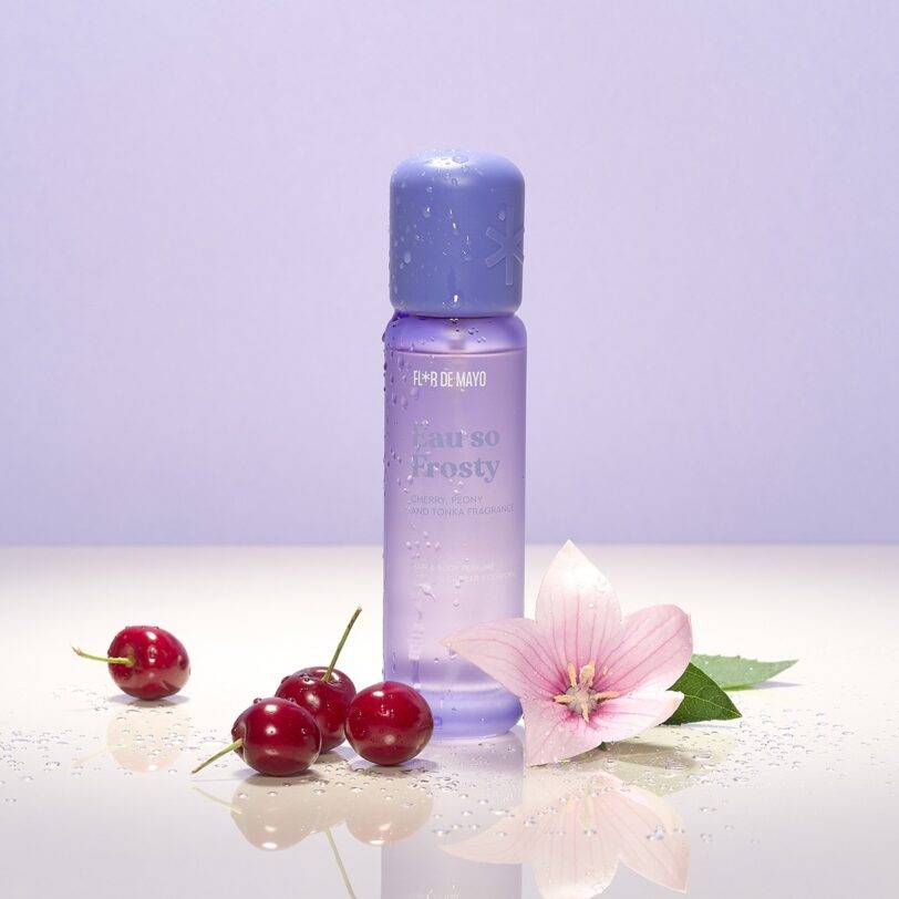 perfume corporal y capilar frosty con aroma a cereza peonia y tonka sobre fondo limpio con frutas y flor