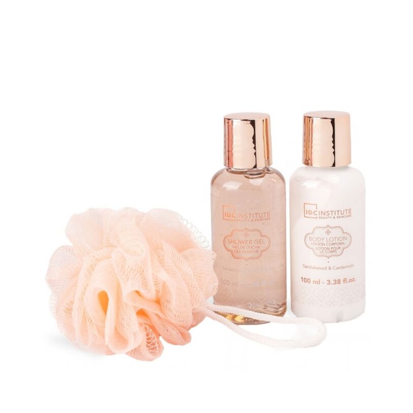 Gel de ducha y loción corporal IDC Institute con aroma a sándalo y cardamomo junto a una esponja de baño