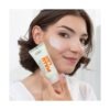 Mujer aplicando la crema facial de día Ziaja Pullulan SPF 20 sobre la mejilla.